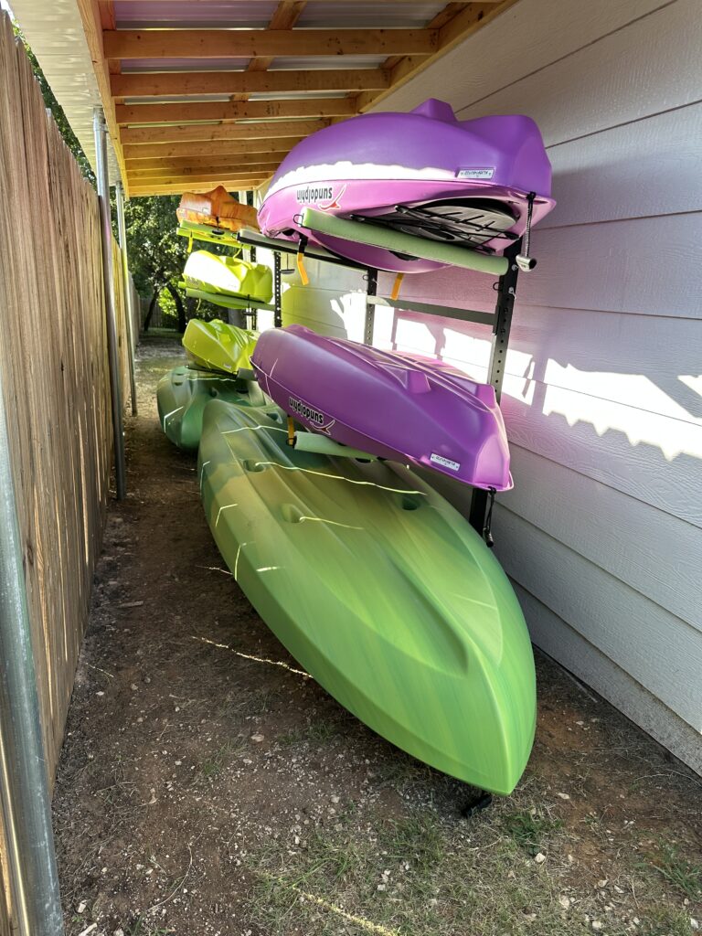 kayaks in different colors and sizes on storage racks