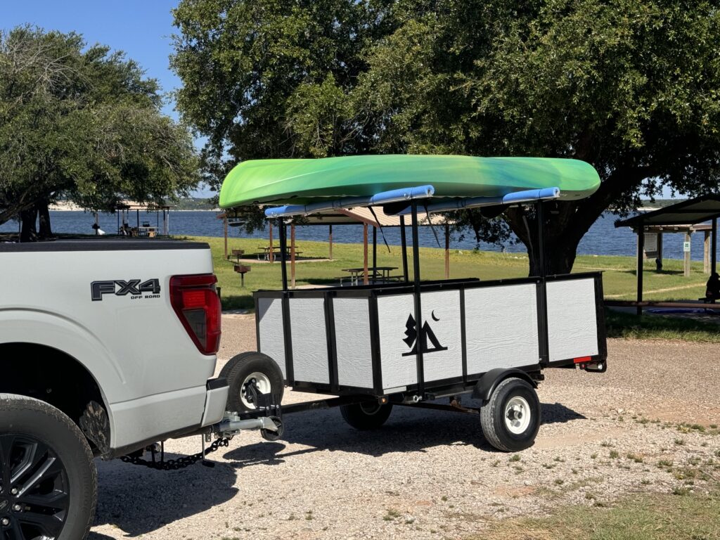 trailer and kayak 2 white kayak trailer carrying a green kayak with a lake in the background